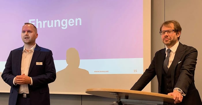 Lars Müller und Michael Kulig stehen bei der BVMS-Jahreshauptversammlung vor der Leinwand mit dem Schriftzug „Ehrungen“ und leiten den offiziellen Ehrungsteil der Veranstaltung ein.