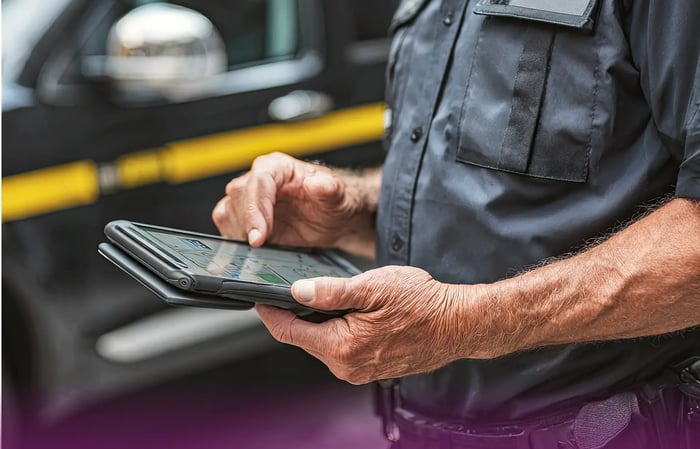 Man holding tablet with a car in the background